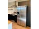 Close up of modern kitchen stainless steel refrigerator, cooktop, and wood shelves at 1040 Stuart St, Denver, CO 80204