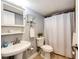 Bathroom featuring a pedestal sink, white fixtures, and tile flooring at 1035 Colorado Blvd # 405, Denver, CO 80206