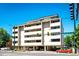 Exterior view of condo building with parking garage, balconies and street access on a bright day at 1035 Colorado Blvd # 405, Denver, CO 80206