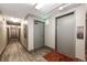 Apartment hallway with grey doors, neutral walls, wood floors, and elevator access at 1035 Colorado Blvd # 405, Denver, CO 80206