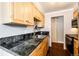 The kitchen includes black granite countertops, wood floors and cabinets, and stainless steel appliances at 1035 Colorado Blvd # 405, Denver, CO 80206