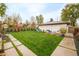 Spacious backyard with a lush lawn, swing set, and comfortable seating area at 2658 Wolff St, Denver, CO 80212