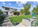 Backyard featuring covered patio, dining area, lush lawn, and mature trees at 2658 Wolff St, Denver, CO 80212