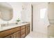 Modern bathroom with double vanity, stylish lighting, and large round mirror at 2658 Wolff St, Denver, CO 80212