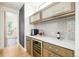 Elegant butler's pantry with custom cabinets, wine refrigerator, and tiled backsplash at 2658 Wolff St, Denver, CO 80212