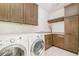 Functional laundry room with ample cabinet space, utility sink and front-load washer and dryer at 2658 Wolff St, Denver, CO 80212