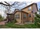 A backyard featuring a covered patio, lush lawn, and mature trees at 3472 Harvard Pl, Broomfield, CO 80023
