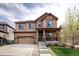 Two-story home featuring stone accents, a covered porch, and a two-car garage at 3472 Harvard Pl, Broomfield, CO 80023