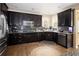 Well-lit kitchen boasts dark cabinets, stainless steel appliances, and a functional layout with plenty of counter space for cooking at 3472 Harvard Pl, Broomfield, CO 80023