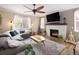 Cozy living room featuring a fireplace, ceiling fan, and comfortable seating, perfect for relaxing and enjoying the natural light at 3472 Harvard Pl, Broomfield, CO 80023