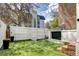 Backyard with green lawn, white fence, and walkout basement access point on house at 2 N Pennsylvania St, Denver, CO 80203