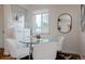 Cozy dining area with glass-top table, white chairs, and natural light at 1235 S Zenobia St, Denver, CO 80219
