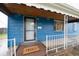 Welcoming blue home featuring covered porch and a 'Hello' doormat at 1235 S Zenobia St, Denver, CO 80219