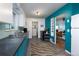 Well-lit kitchen with stainless appliances, blue cabinetry, and sleek countertops at 1235 S Zenobia St, Denver, CO 80219