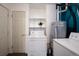 Functional laundry room with appliances, shelving, and ample space for household chores at 1235 S Zenobia St, Denver, CO 80219
