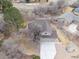 An aerial view of a beige home with a three car garage in a wooded neighborhood and bare landscaping at 8150 Tempest Ridge Way, Parker, CO 80134