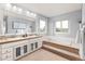 Bright bathroom with a large mirror, a dual sink vanity, and a luxurious soaking tub with tiered access at 8150 Tempest Ridge Way, Parker, CO 80134