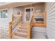 Inviting front porch with wood railings, accent lighting, and decorative tree carving at 8150 Tempest Ridge Way, Parker, CO 80134