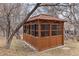 Stylish enclosed gazebo with wood siding and paned windows, nestled in a serene backyard setting at 8150 Tempest Ridge Way, Parker, CO 80134