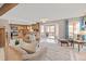 Bright and open living area with a fireplace, sliding glass doors to the deck, and views into the kitchen at 8150 Tempest Ridge Way, Parker, CO 80134