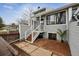 Gray townhome features a cozy brick patio and wooden steps with white railing leading to the front entrance at 378 Owl Dr, Louisville, CO 80027