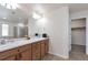 Bright bathroom features double sinks, wood cabinets, and a large mirror, with access to a walk-in closet at 12217 Skywalk St, Parker, CO 80134