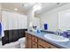 Cozy bathroom featuring a single sink, vanity with wooden drawers, and a shower with black and white curtains at 12217 Skywalk St, Parker, CO 80134