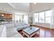 Open-concept living room featuring hardwood floors, large windows, and a view of the kitchen at 12217 Skywalk St, Parker, CO 80134