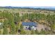Aerial view of a home nestled among trees, showcasing the surrounding landscape at 24699 Us Hwy 40, Golden, CO 80401