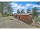 Exterior view of the property showcasing a stone retaining wall and wooded surroundings at 24699 Us Hwy 40, Golden, CO 80401