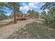 Exterior view of a home with a deck, pergola, and surrounding trees at 24699 Us Hwy 40, Golden, CO 80401