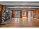 Living room features exposed beams, stone fireplace, wood paneling, and hardwood floors at 24699 Us Hwy 40, Golden, CO 80401
