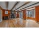 Living room features exposed beams, stone fireplace, wood paneling, and hardwood floors at 24699 Us Hwy 40, Golden, CO 80401