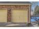 Attached garage with pale yellow door and brick exterior at 13791 E Lehigh Ave # A, Aurora, CO 80014