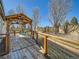 Wood deck with metal railing, a wooden pergola and outdoor furniture, perfect for outdoor relaxation at 2227 Chestnut Cir, Erie, CO 80516