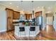 Kitchen with an island, hardwood floors, pendant lighting, and stainless-steel appliances in an open concept layout at 2227 Chestnut Cir, Erie, CO 80516