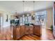 Gourmet kitchen island with granite countertops and wood cabinets, open to the living area with hardwood floors at 2227 Chestnut Cir, Erie, CO 80516