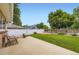 Private backyard with a concrete patio, lawn, mature trees, and a white vinyl fence at 3743 W 103Rd Dr, Westminster, CO 80031