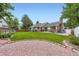 Well-maintained backyard with grass, mature trees, and brick detailing, perfect for outdoor enjoyment at 3743 W 103Rd Dr, Westminster, CO 80031