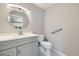 A half-bath with grey vanity, sleek fixtures, white toilet, and grey hexagonal tile floor at 3743 W 103Rd Dr, Westminster, CO 80031