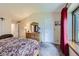 Bedroom with warm decor, including wooden furniture, a bed, and a window with red curtains at 3743 W 103Rd Dr, Westminster, CO 80031