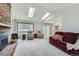 Bright living room with a brick fireplace, skylights, and access to the kitchen at 3743 W 103Rd Dr, Westminster, CO 80031