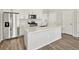 Kitchen with stainless steel refrigerator, gas range, microwave, white cabinets and countertops, and hardwood floors at 755 N Tibet St, Aurora, CO 80018