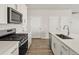 Well-lit kitchen features stainless appliances, a gas range, and sleek white cabinets and countertops at 755 N Tibet St, Aurora, CO 80018