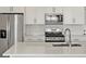 Modern kitchen featuring stainless steel appliances, white cabinetry and quartz countertops at 755 N Tibet St, Aurora, CO 80018
