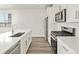 Modern kitchen boasts stainless appliances, gas range, white cabinets and countertops and hardwood floors at 755 N Tibet St, Aurora, CO 80018