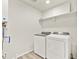 Laundry room with washer, dryer, shelves, and modern gray wood-look flooring at 755 N Tibet St, Aurora, CO 80018