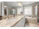 Bathroom featuring dual vanity sinks, granite countertops, and separate soaking tub and shower at 7268 Greenwater Cir, Castle Rock, CO 80108