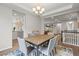 Traditional dining room with wood table, gray chairs, overhead lighting, and open doorway to living room at 7268 Greenwater Cir, Castle Rock, CO 80108