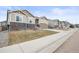 Street view of a row of homes with well-manicured lawns, two-car garages, and stone accents at 7268 Greenwater Cir, Castle Rock, CO 80108